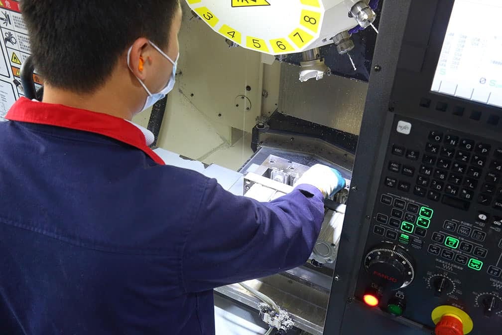 操作人員在氣動氣缸工廠的 FANUC CNC 加工中心作業